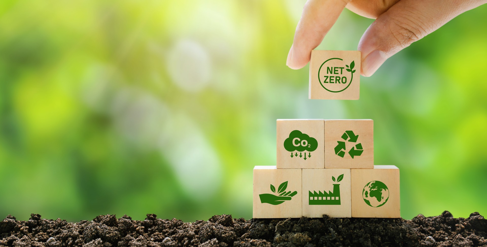 DATACURVE - Net Zero and Carbon Neutral Concepts Net Zero Emissions Goals A climate-neutral long-term strategy Ready to put wooden blocks by hand with green net center icon and green icon on gray background.